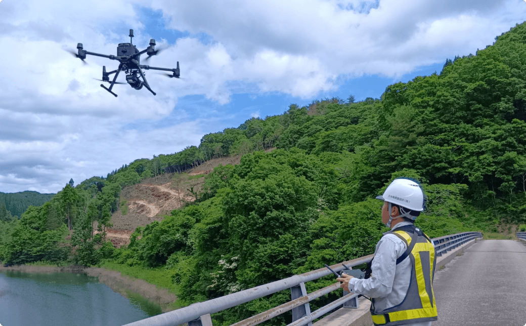 UAVドローンによる地形測量・三次元点群測量で森林斜面を計測する作業員